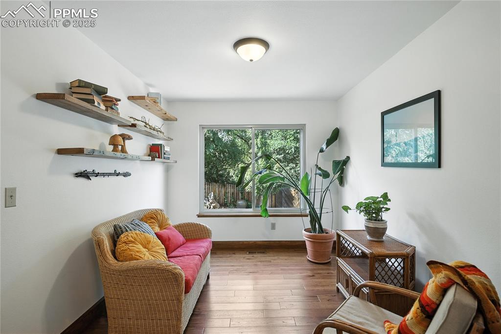 Image 10 of 50: Living area featuring wood-type flooring and baseboards