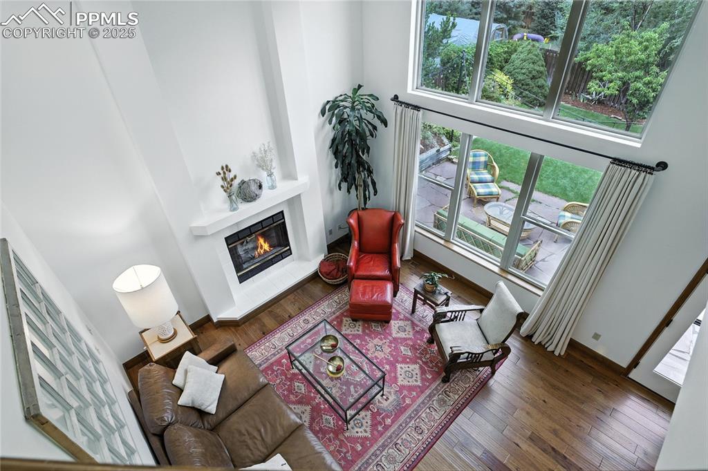 Image 26 of 50: Living room featuring a glass covered fireplace, wood finished floors, and 