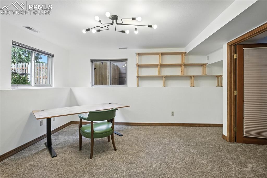 Image 30 of 50: Office area featuring carpet flooring and a chandelier