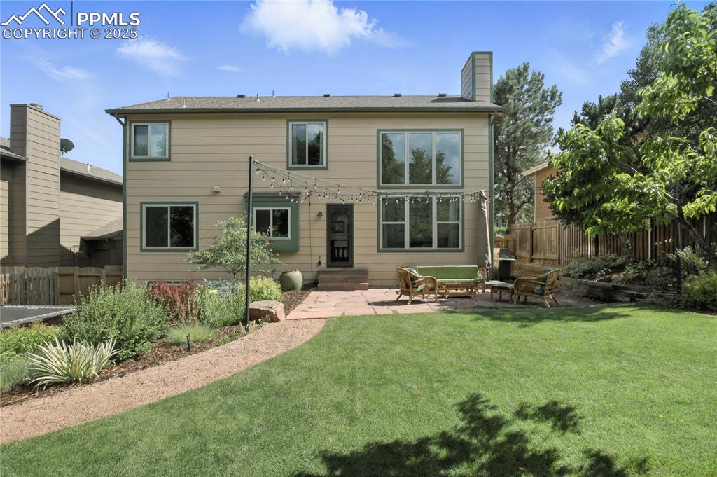 Image 38 of 50: Rear view of house featuring a chimney, a patio area, and entry steps