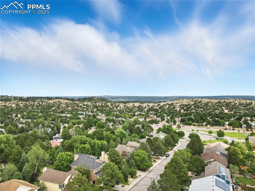 Image 46 of 50: Aerial view of residential area with a tree filled landscape