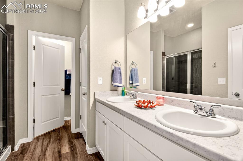 Image 15 of 31: En suite with double sinks, tile surround shower w/bench seating and a larg