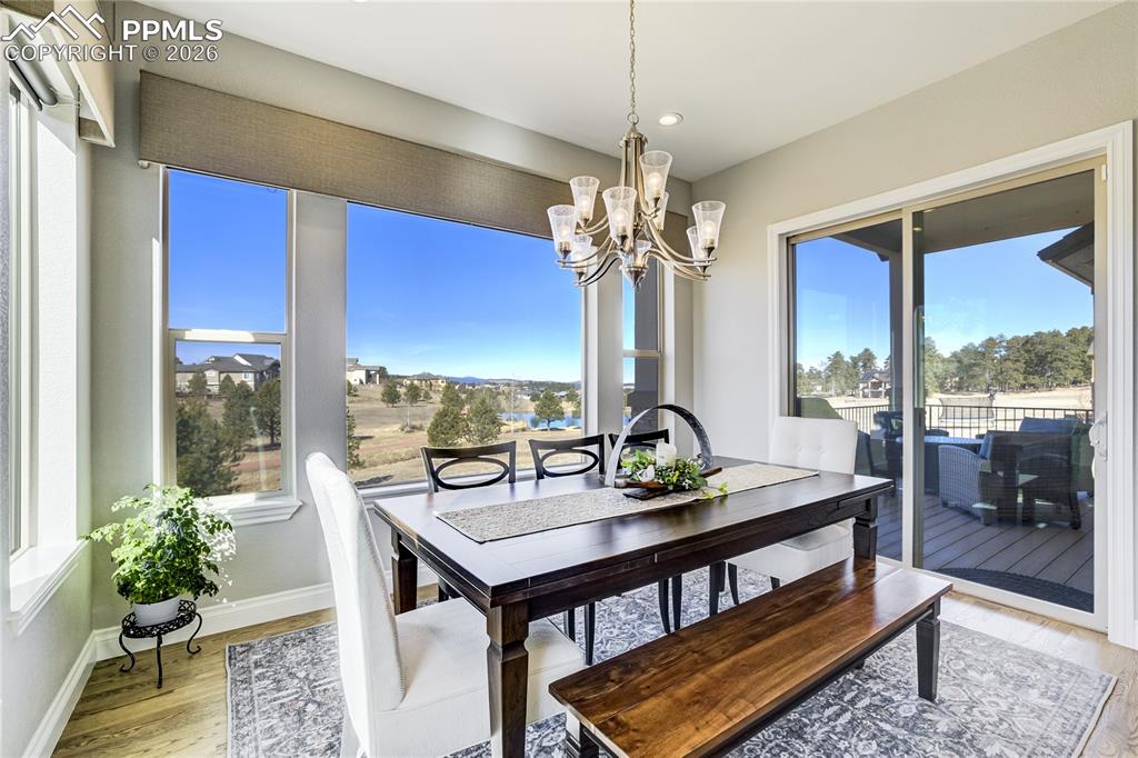 Image 12 of 50: Dining space positioned to capture pond + mountain outlook with seamless tr