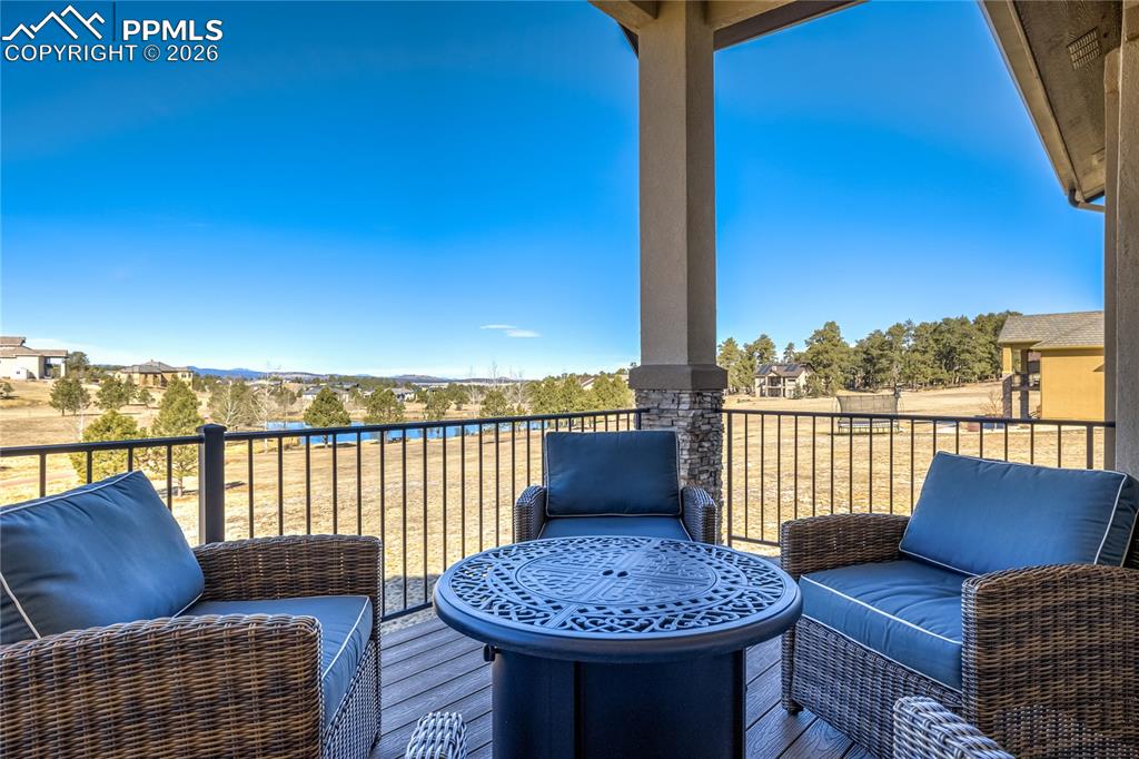 Image 15 of 50: Covered composite deck extending the main-level living—elevated above the l