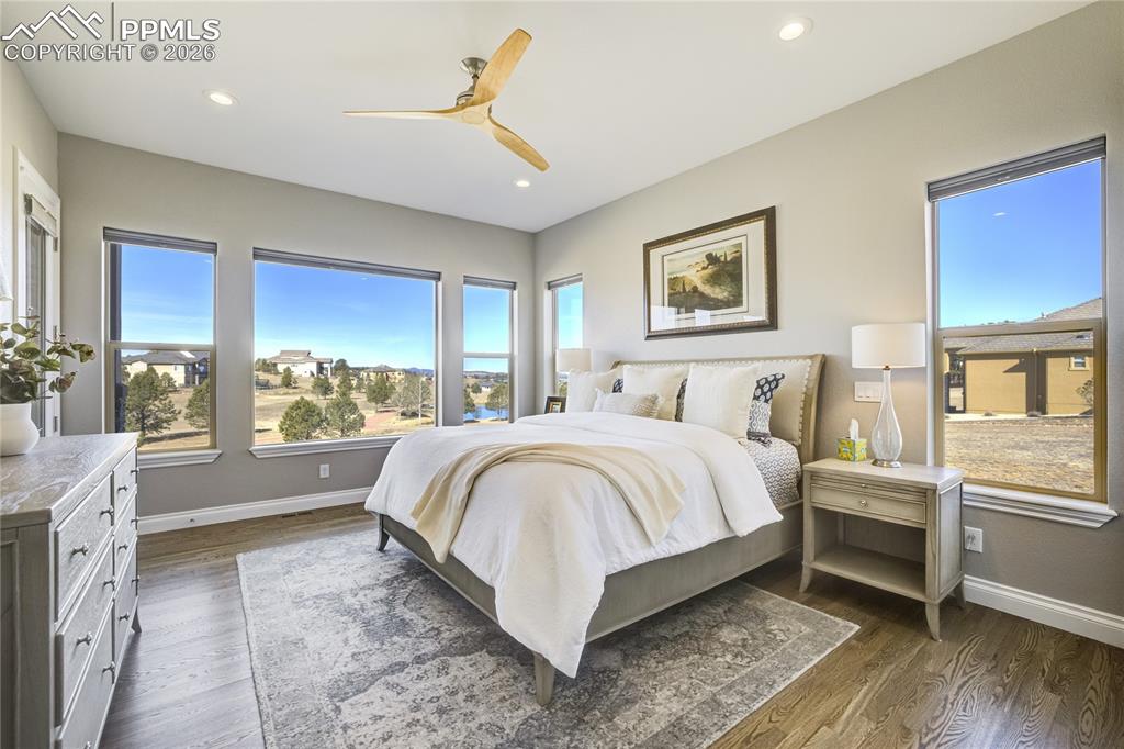 Image 17 of 50: Privately situated owner’s suite with hardwood floors and corner-window vie