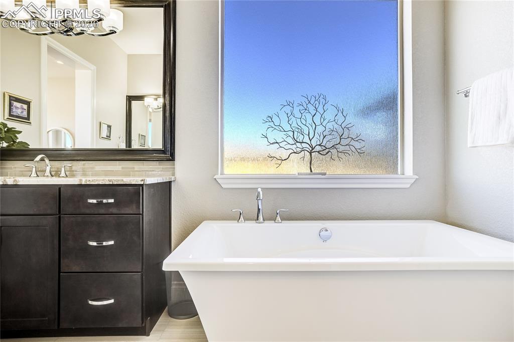 Image 20 of 50: Spa-inspired bath with freestanding soaking tub, dual vanities and zero-ent