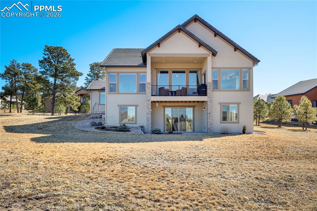 Image 41 of 50: Elevated rear façade showcasing covered composite deck above walk-out patio