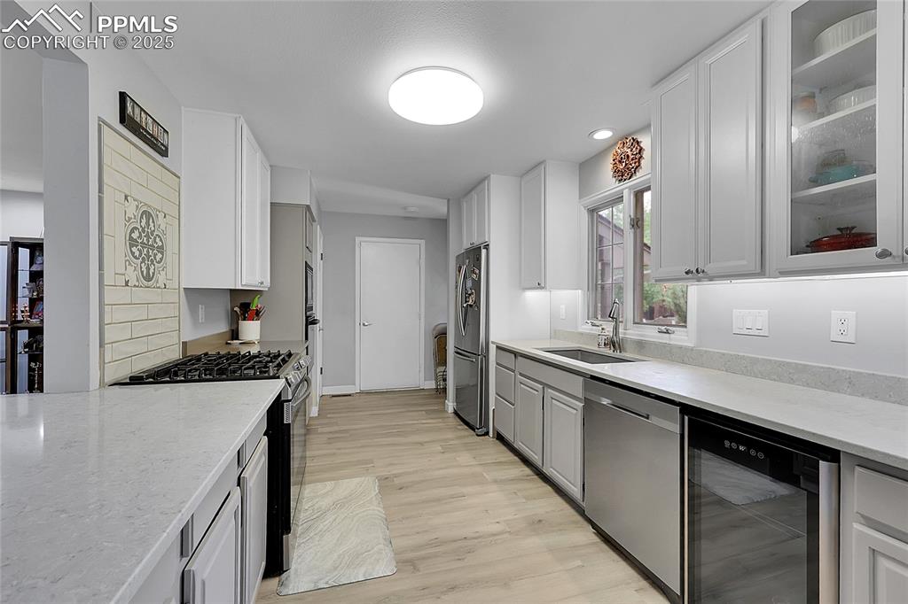 Image 12 of 36: Kitchen featuring appliances with stainless steel finishes, wine cooler, li
