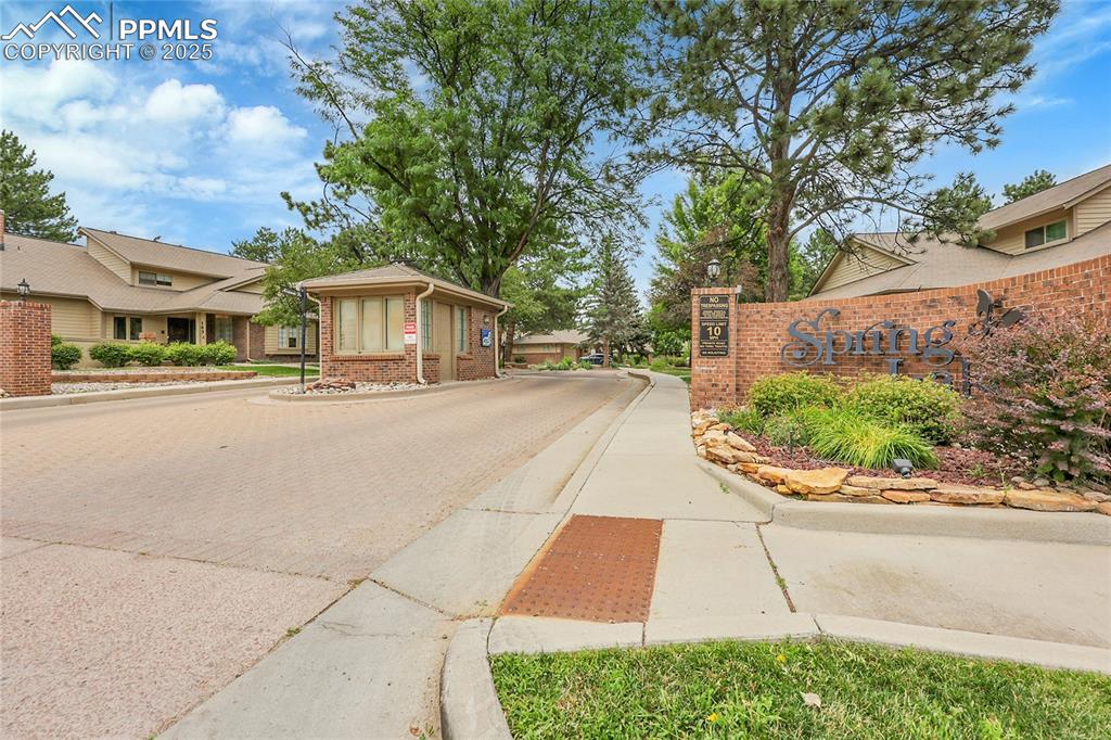 Image 35 of 36: View of street featuring curbs, sidewalks, and a gated entry