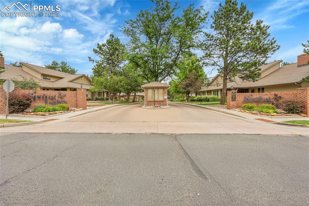 Image 36 of 36: View of asphalt road with curbs, sidewalks, a residential view, and traffic