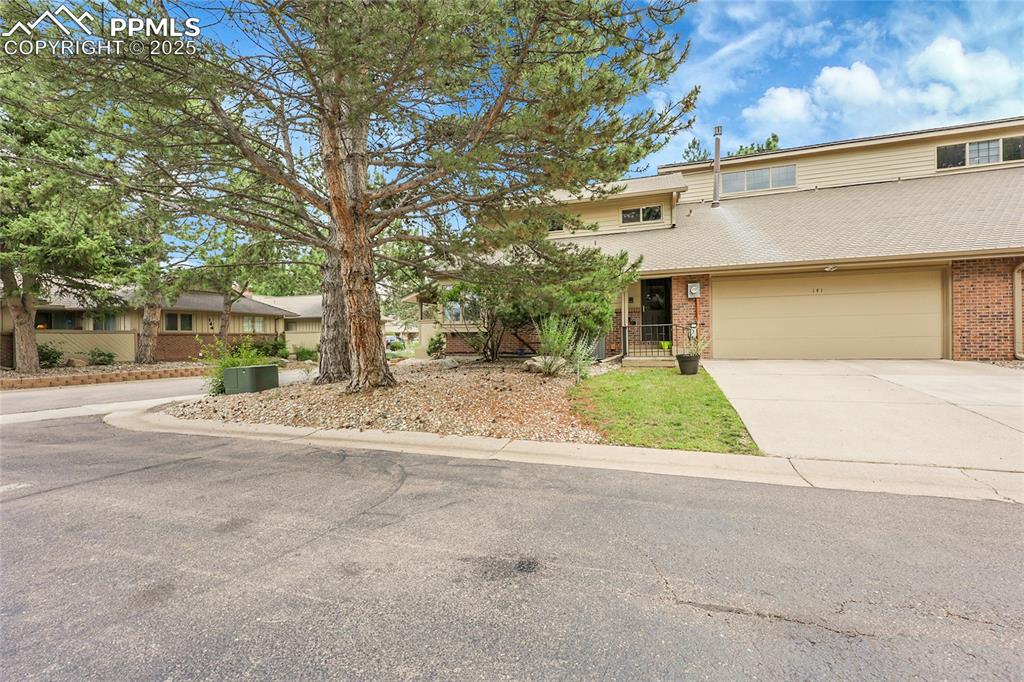 Image 5 of 36: View of front of property with brick siding, concrete driveway, and a garag