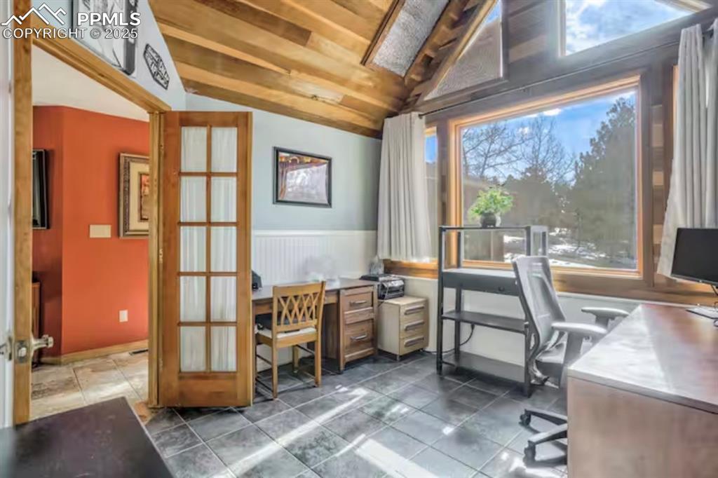 Image 21 of 48: Office area with vaulted ceiling, wood ceiling, and a wainscoted wall