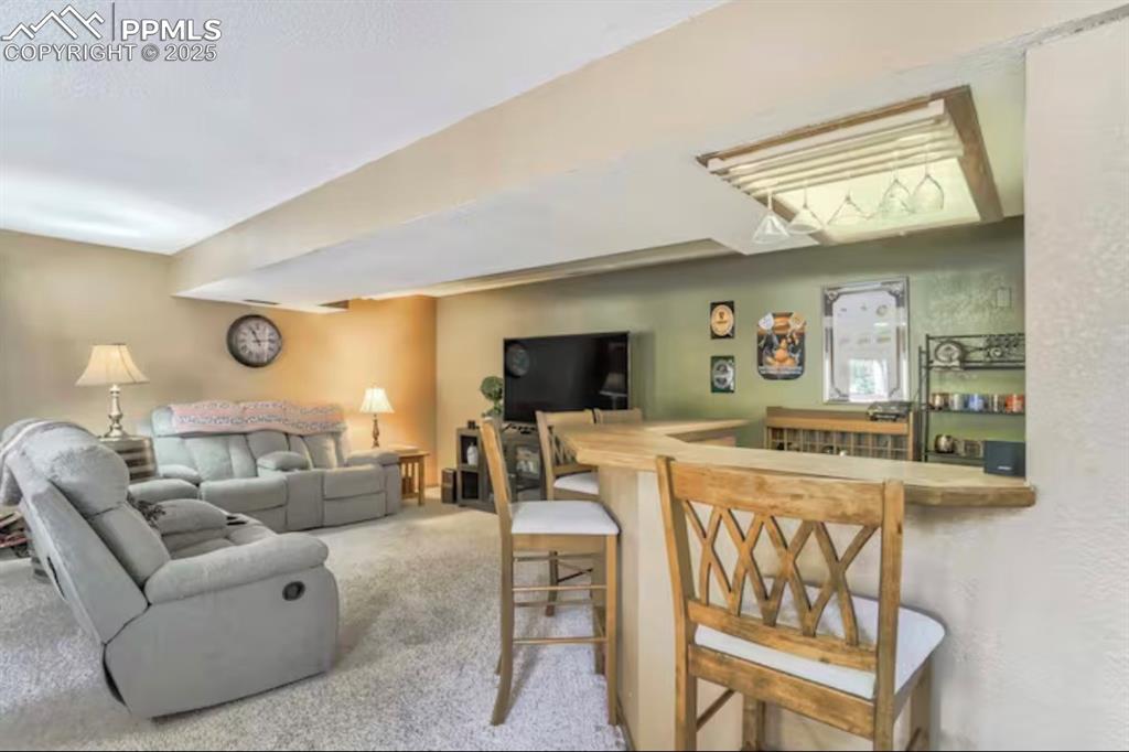 Image 28 of 48: Living area featuring carpet floors