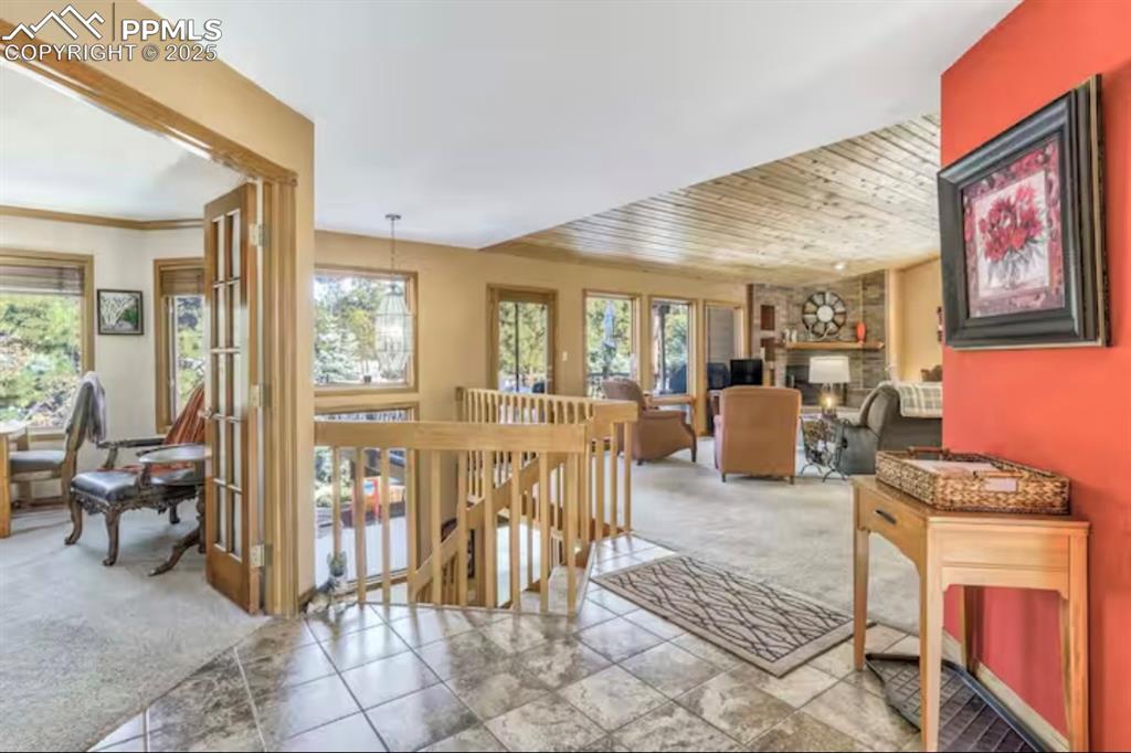 Image 3 of 48: Hallway featuring carpet floors, an upstairs landing, and wooden ceiling