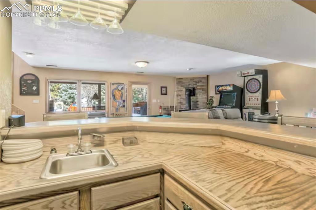 Image 30 of 48: Kitchen with light countertops, a textured ceiling, and open floor plan