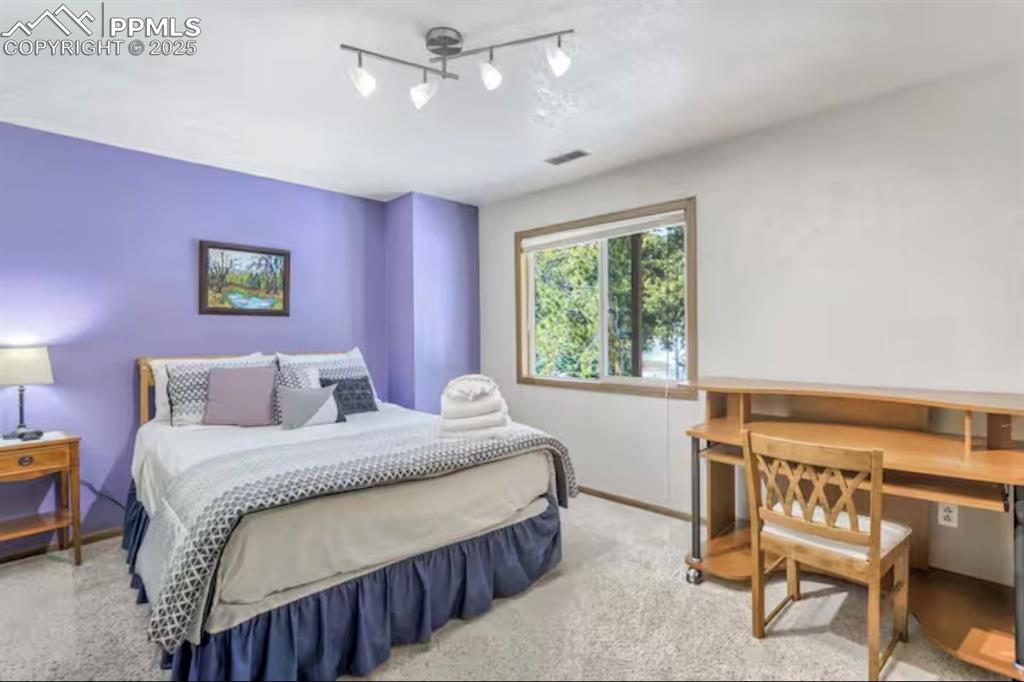 Image 33 of 48: Carpeted bedroom featuring an office area