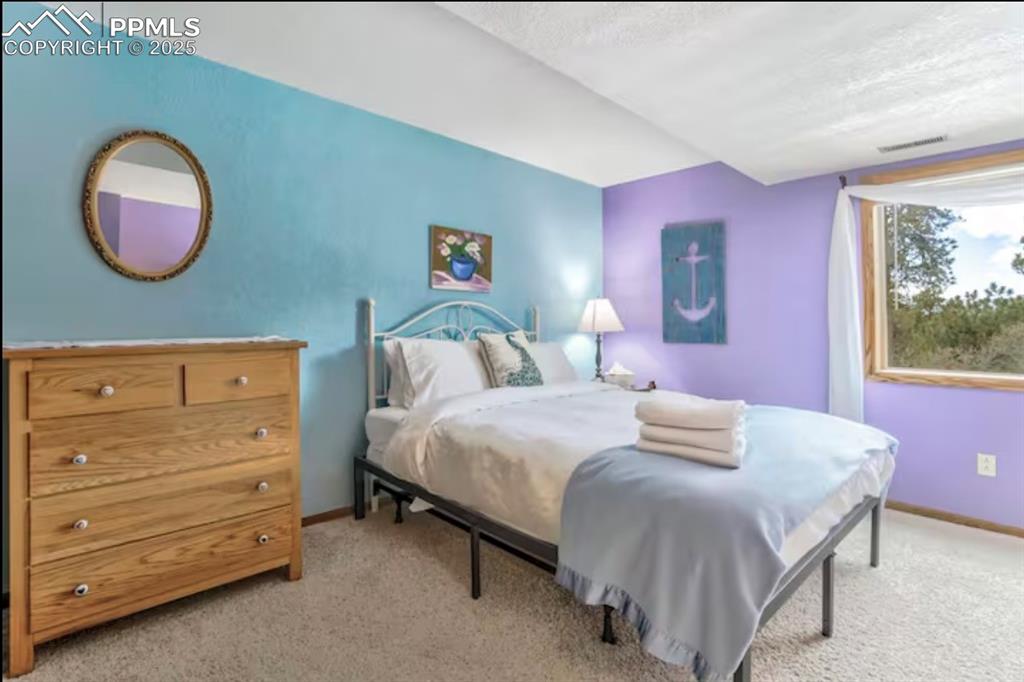Image 34 of 48: Bedroom featuring light carpet and a textured ceiling