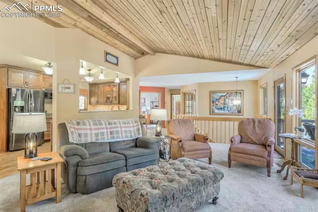 Image 7 of 48: Carpeted living room with wooden ceiling and vaulted ceiling