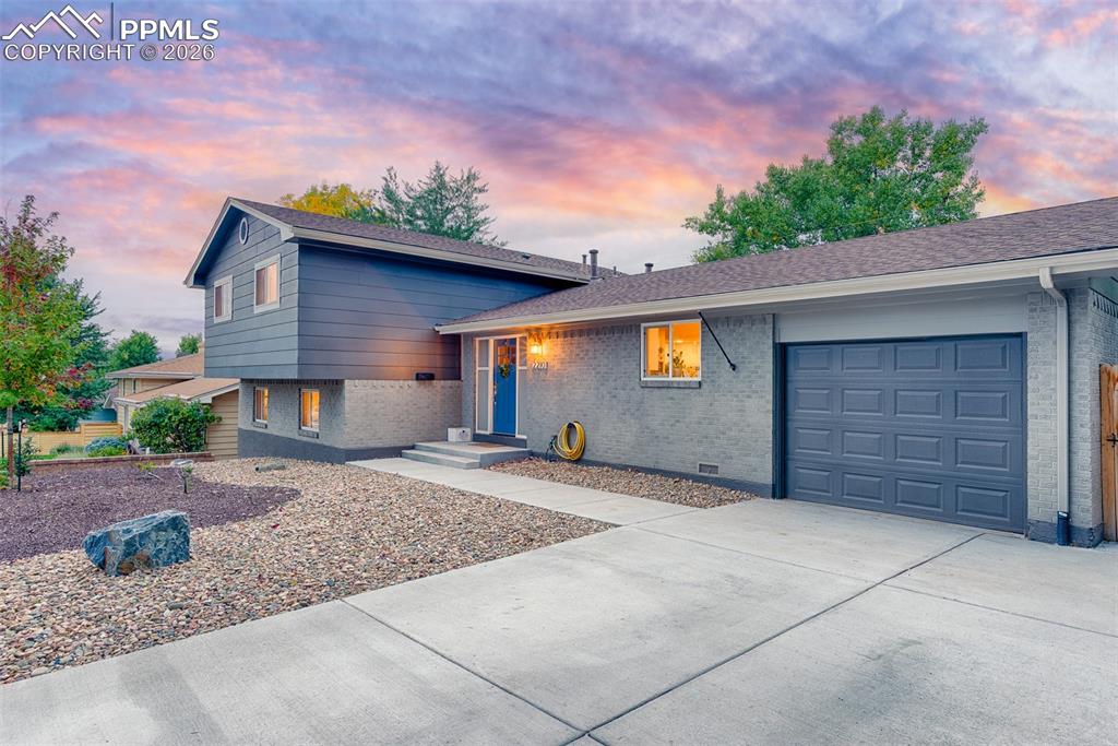 Image 7 of 50: Front of the home with xeriscaping and extra wide driveway
