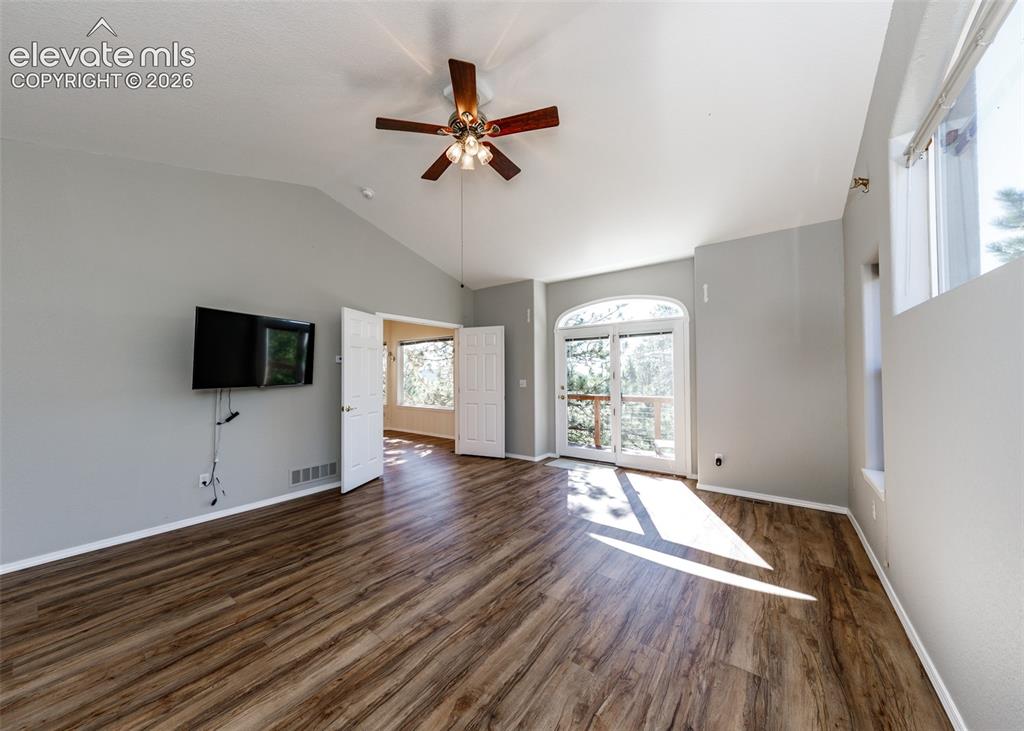 Image 13 of 48: Vaulted ceiling, wood-finish flooring, ceiling fan with integrated lighting