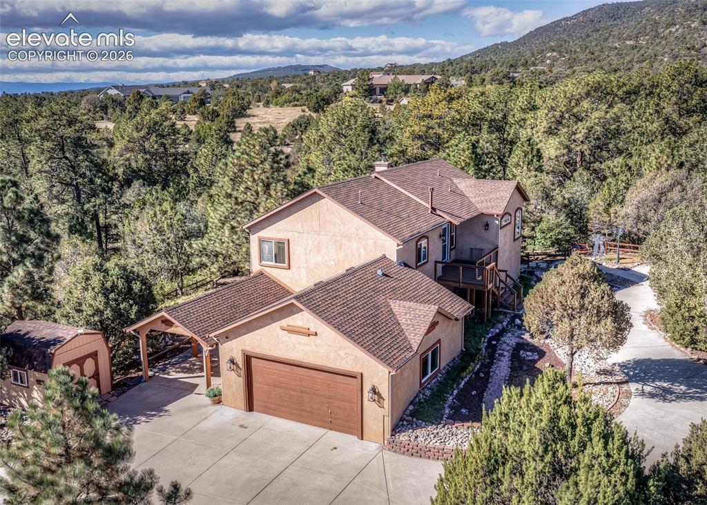 Image 2 of 48: Two-story stucco residence featuring an attached two-car garage, covered ca