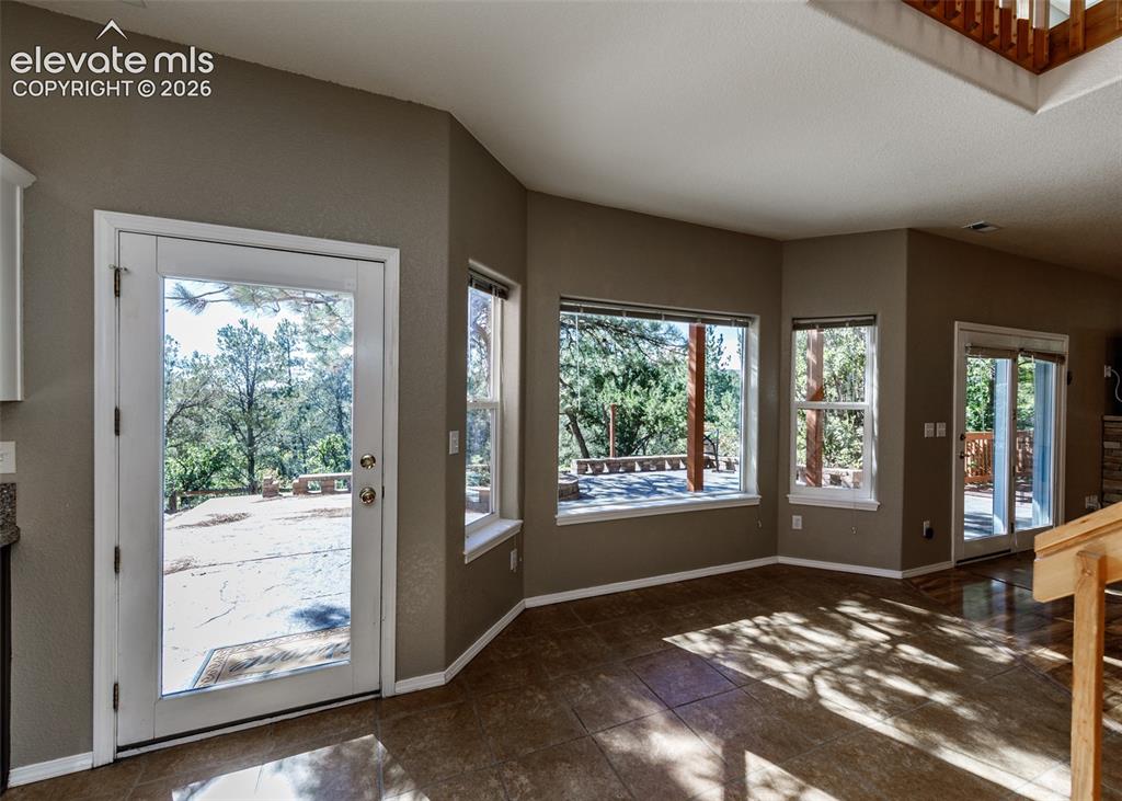 Image 30 of 48: Side Entrance - Large-format tile flooring, multiple picture windows, full-