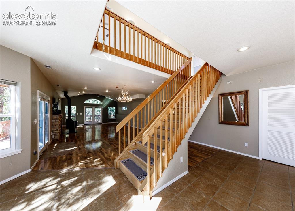 Image 31 of 48: Open-concept interior featuring wood-finish flooring, a vaulted ceiling, re