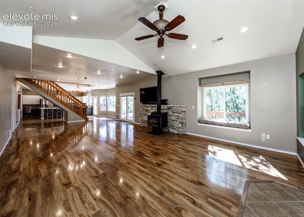 Image 32 of 48: Vaulted ceilings with recessed lighting, wood-finish flooring, stone-surrou