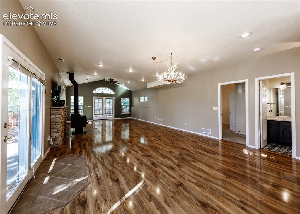 Image 36 of 48: Open-concept interior featuring wood-finish flooring, a vaulted ceiling wit