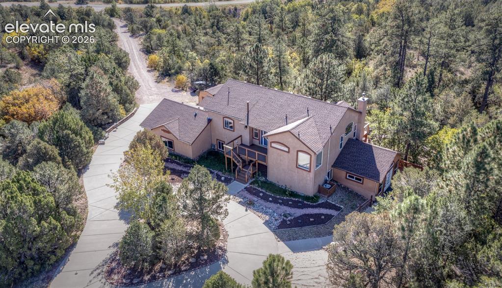 Image 46 of 48: Stucco exterior residence featuring an expansive concrete driveway, multi-l