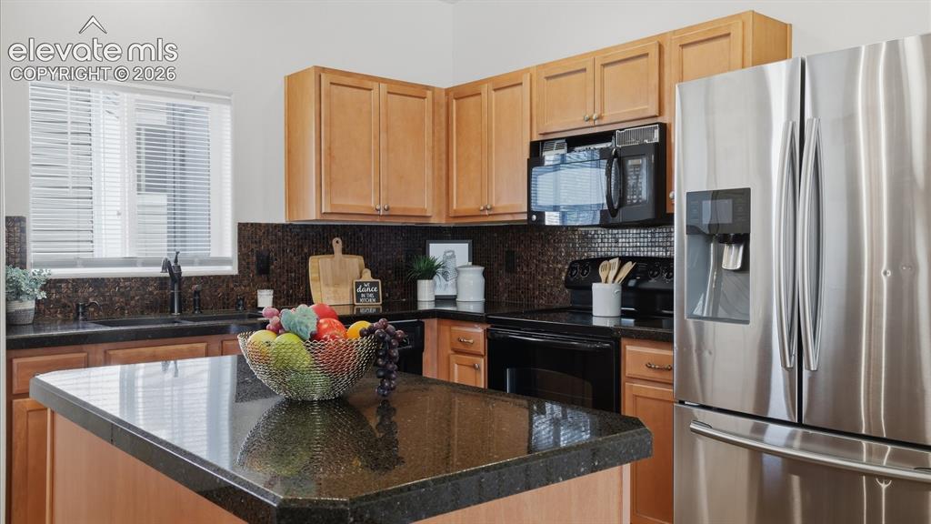 Image 15 of 29: The stylish kitchen features a center island, Italian glass granite overlay