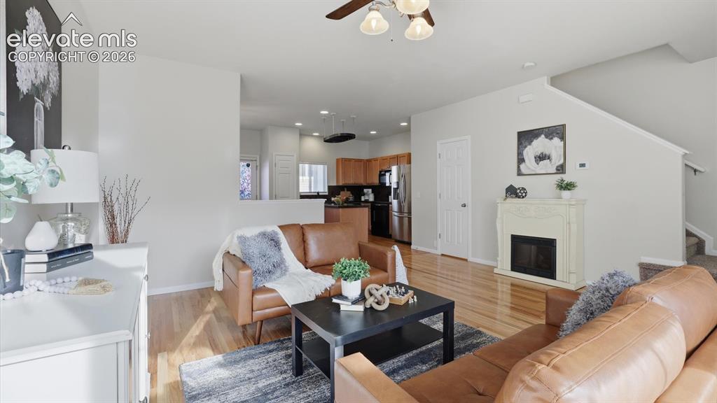 Image 8 of 29: The spacious Living Room features hardwood floors and a lighted ceiling fan