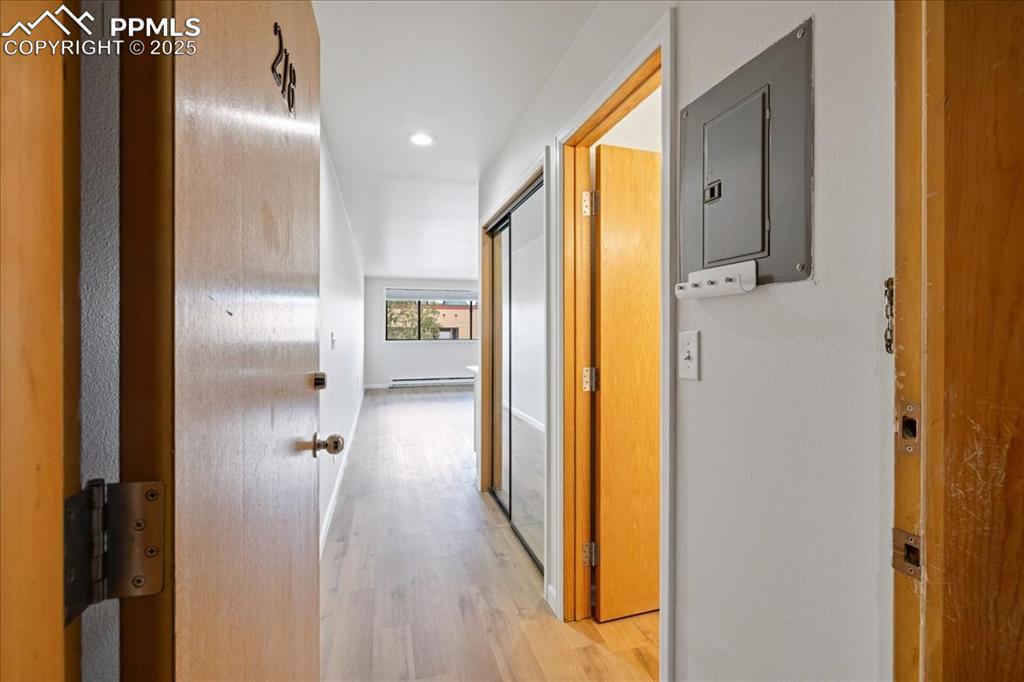 Image 12 of 17: Corridor with light wood-type flooring and electric panel