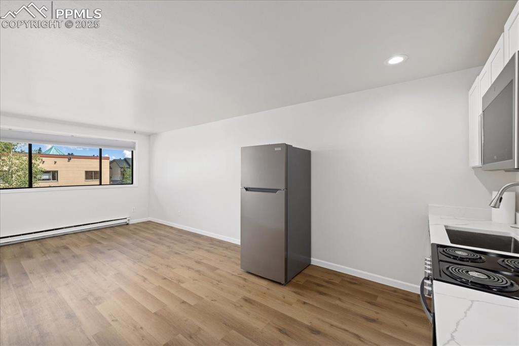 Image 8 of 17: Kitchen featuring stainless steel appliances, light wood-type flooring, lig