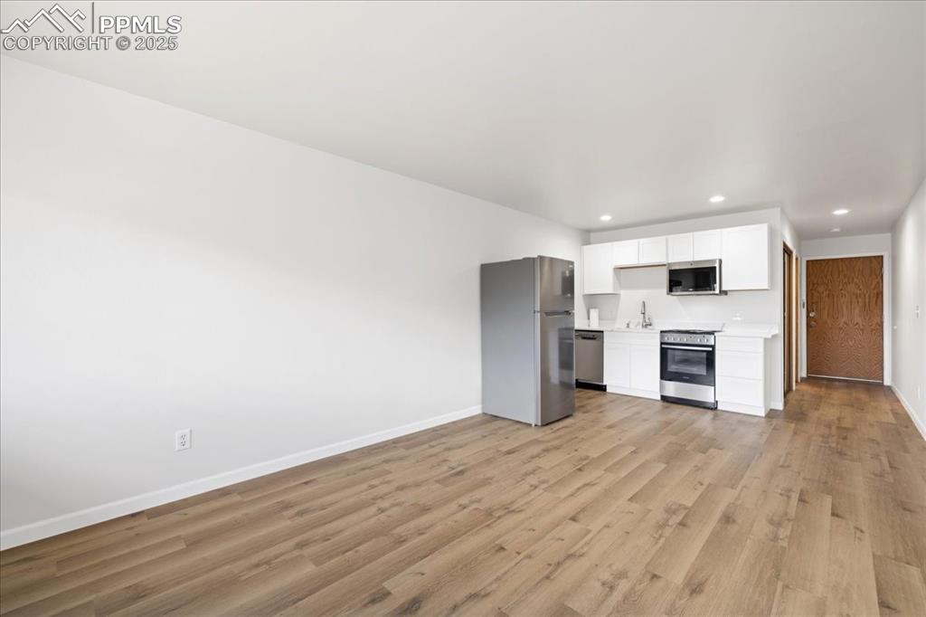 Image 9 of 17: Unfurnished living room with recessed lighting and light wood-style floorin