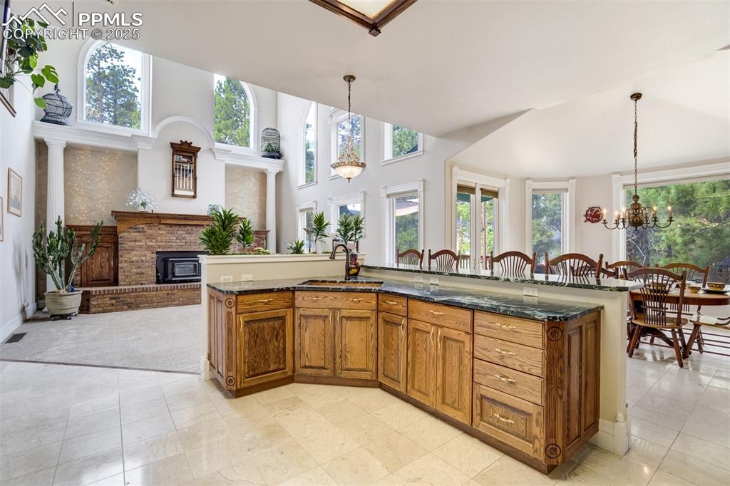Image 13 of 50: Kitchen is open to the living room with cathedral ceilings and massive wind