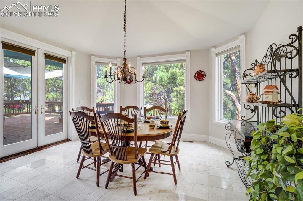 Image 17 of 50: Dining space featuring a chandelier, plenty of natural light, and french do
