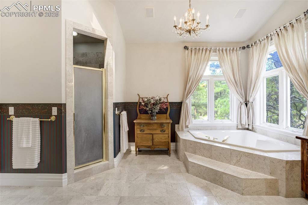 Image 24 of 50: Bathroom featuring lofted ceiling, soaking tub, separate shower and double 
