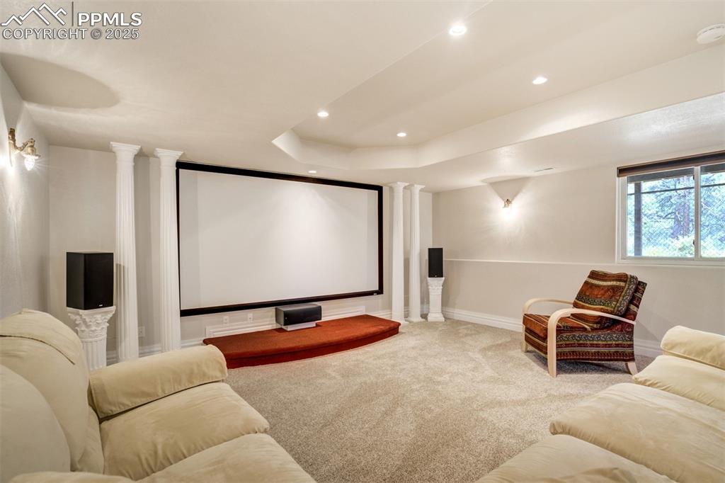 Image 34 of 50: Carpeted cinema room is equipped with all components, furniture and a video