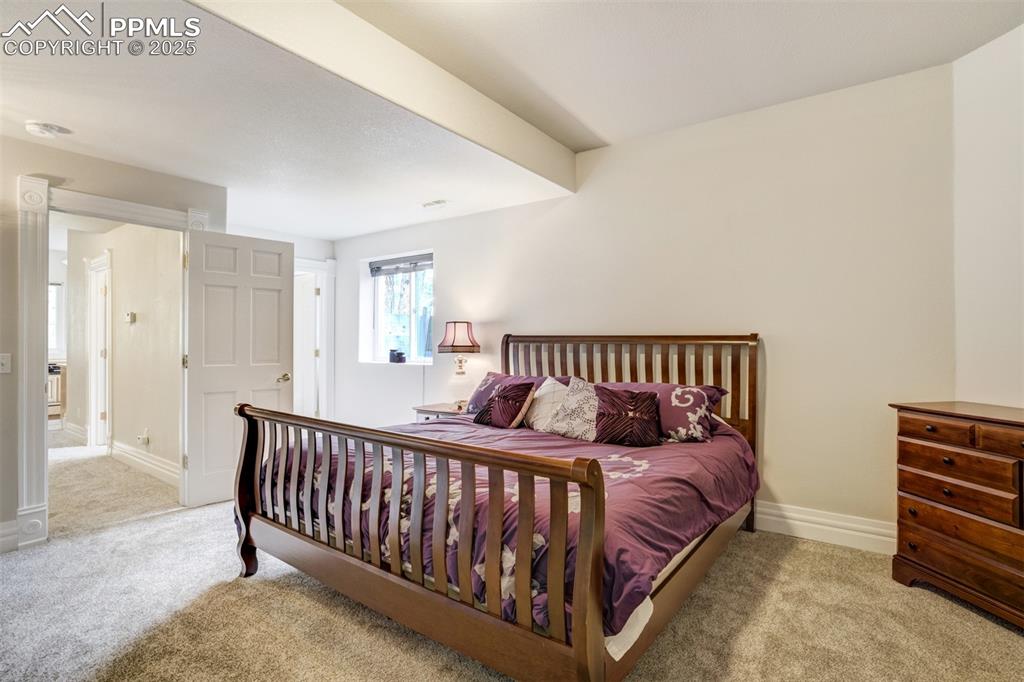 Image 35 of 50: Carpeted bedroom in basement has an adjoining bathroom