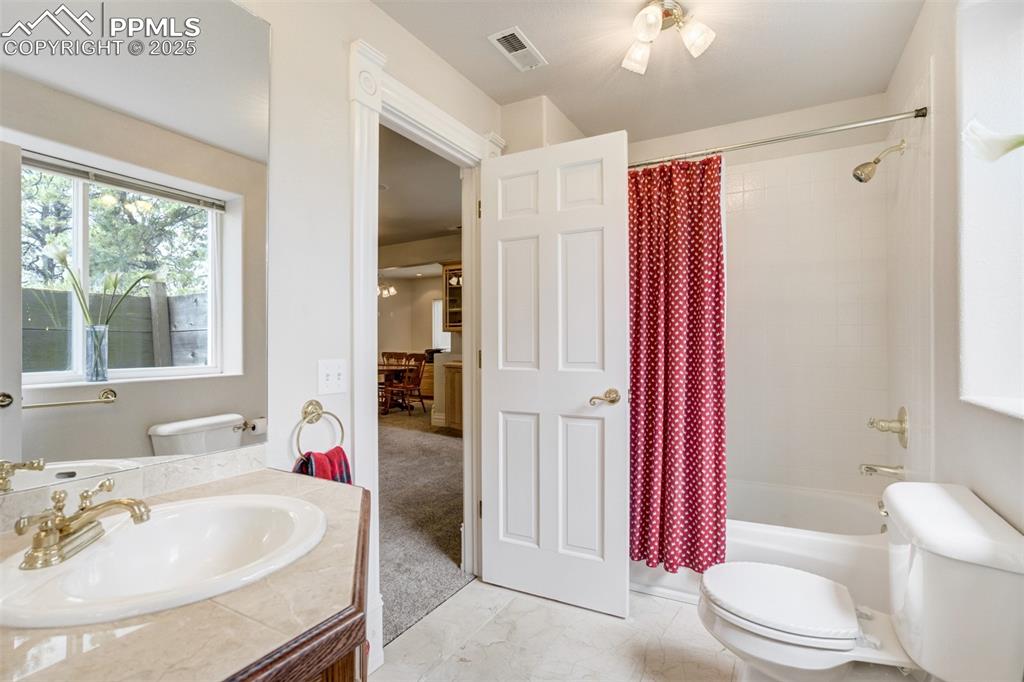Image 36 of 50: Full bathroom with vanity, shower / bath combination with curtain, and marb