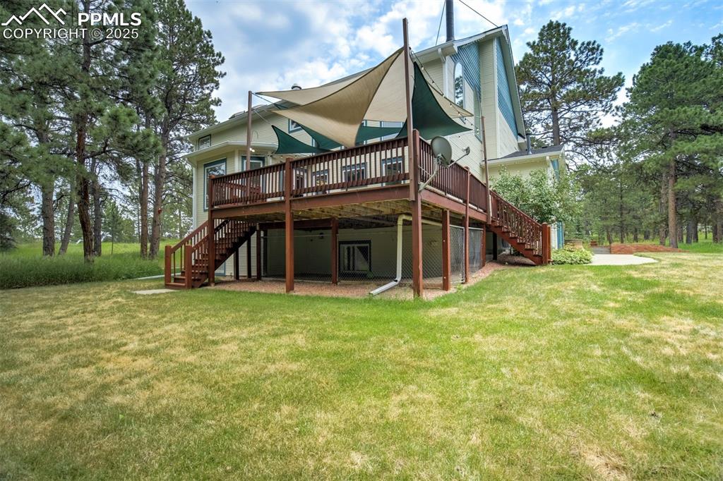 Image 38 of 50: Back of house featuring stairway, a wooden deck, and a yard