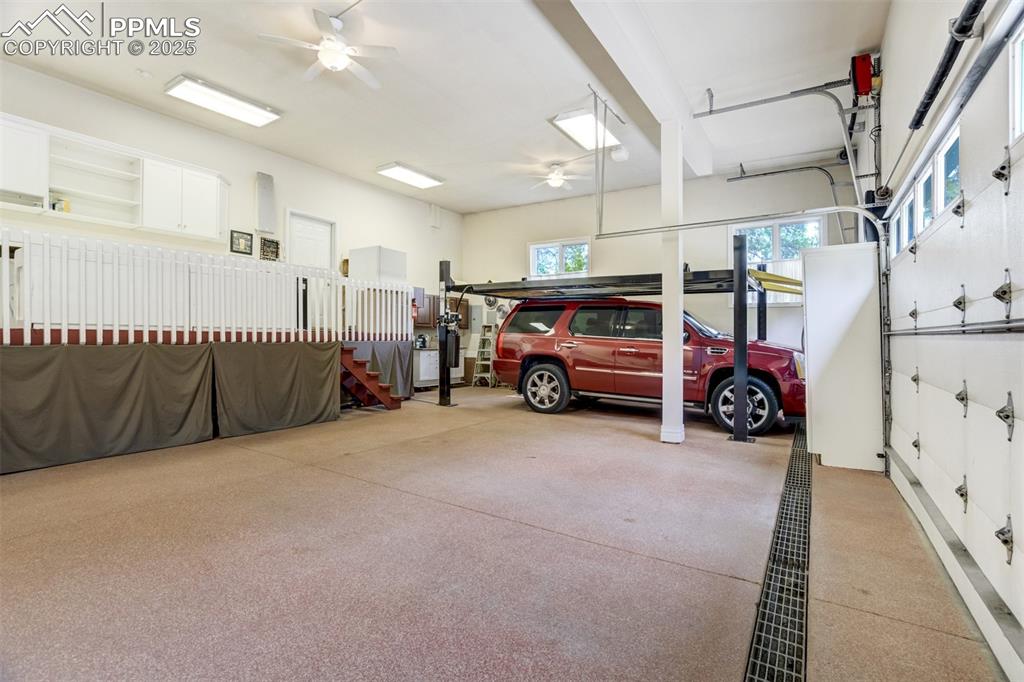 Image 39 of 50: Heated 3-car garage has epoxy flooring and tons of storage and a 9,000 lbs.