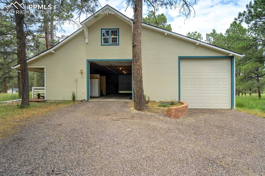 Image 42 of 50: Detached garage/tack room/barn includes four horse stalls, RV garage and a 