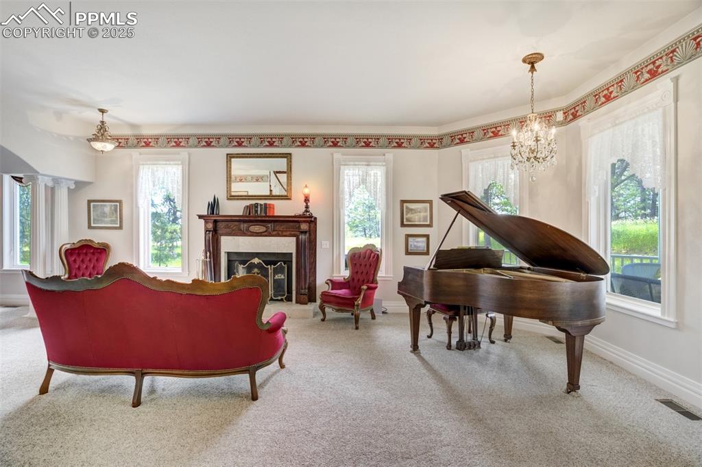 Image 7 of 50: Formal sitting room with turret windows, antique fireplace mantle, gas fire