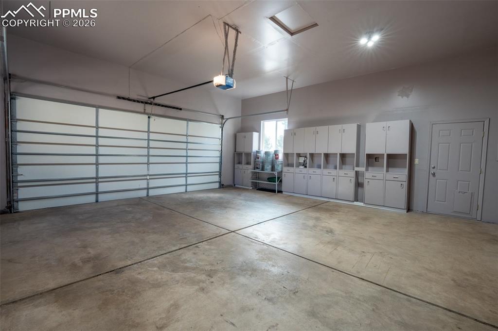 Image 27 of 49: Oversized Attached 2 car garage with 220V space for storage