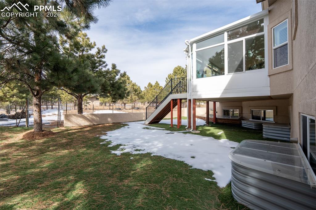 Image 49 of 49: Covered back deck and stairs to the Turf installed in the back and side yar
