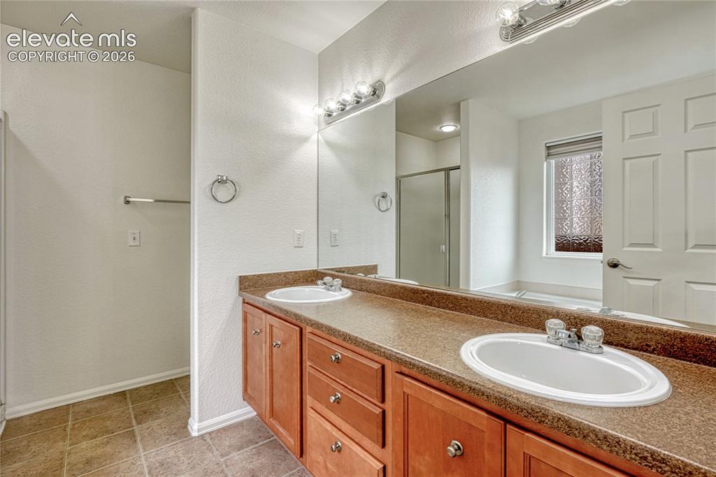 Image 16 of 36: Primary 5-piece bathroom with double vanity.