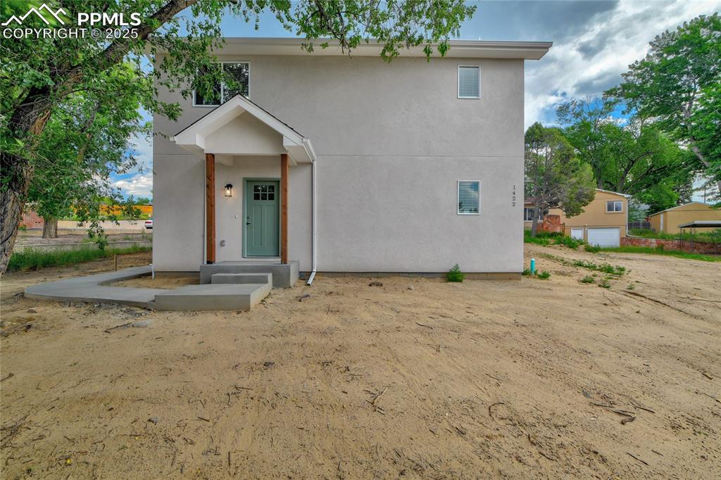 Caption: View of front of property featuring stucco siding