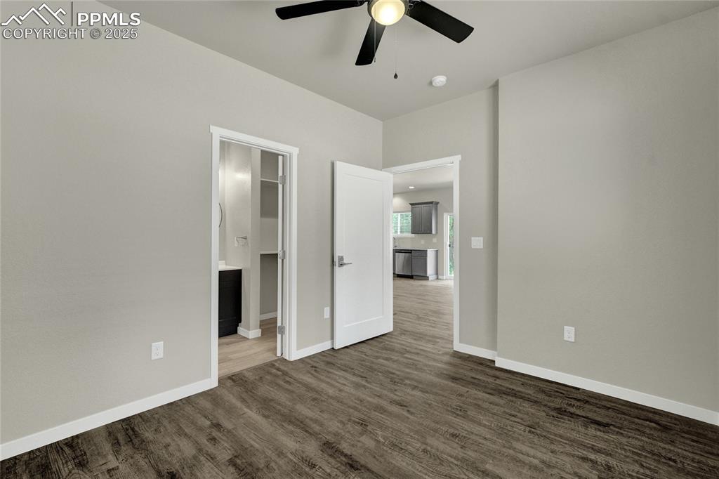 Image 12 of 38: Bedroom with ceiling fan, ensuite bath, and dark wood finished floors
